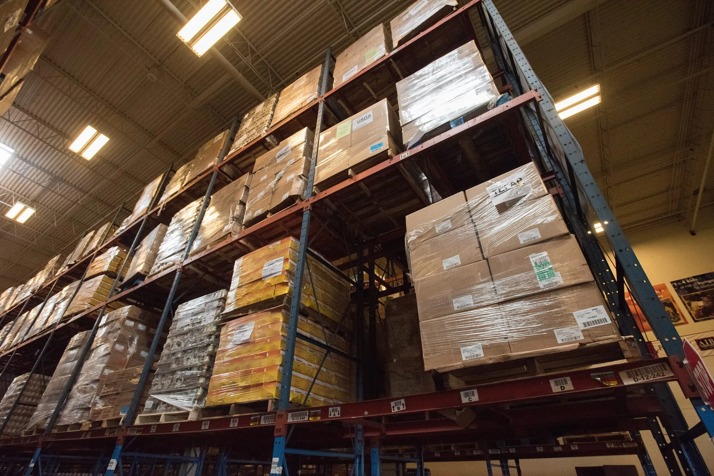 Racked pallets of wrapped cartons in a warehouse